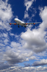 Air travel - Plane is flying in blue sky with clouds