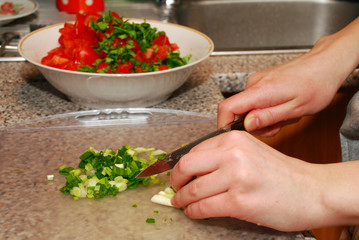 Girl's hands cut salad with knife
