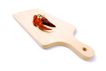 Dried-up red paprika on kitchen board