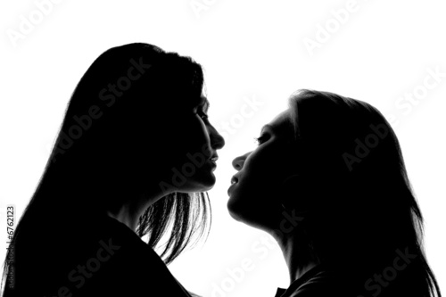 "A silhouette of two attractive women almost kissing ...
