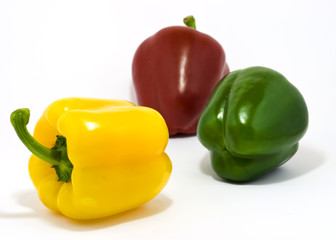 Three colored paprikas on white background