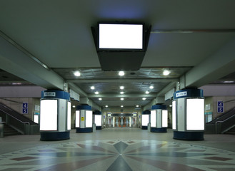 Underground train station with escalators and billboard colums
