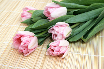 Pink tulips on a straw napkin