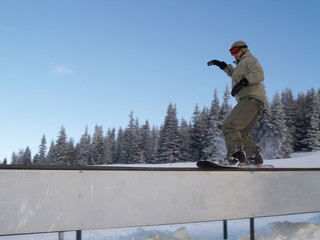 Snowboarder sliding on rail.