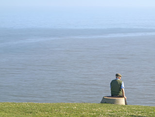 Anciano con gorra mirando al mar