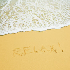 relax written in a sandy tropical beach