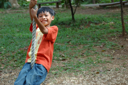 Boy Playing On Rope Swing