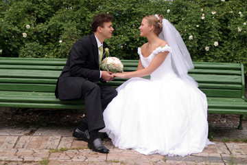Newlywed bride and groom on bench