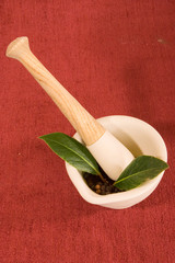 Pestle in Mortar with Bay Leaves and Peppercorns