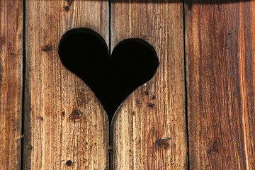Fototapeta na wymiar Serce wyryte w stronę drewnianej chatki