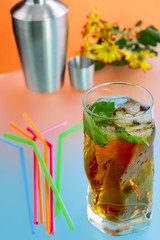 Glass of ice tea and on background of cocktail shaker