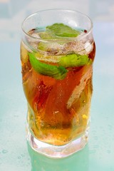 Glass of ice tea on blue background