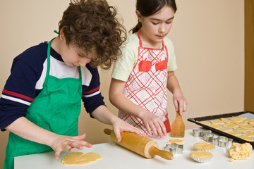 Young girl and boy baking cakes