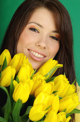 Sexy girl with yellow tulips. green background