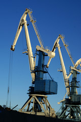 Image of an industrial port large cranes against blue sky