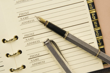 Silver fountain pen on stylish address book
