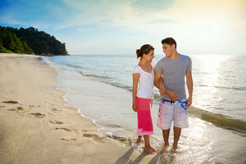 happy couple walking along the beach