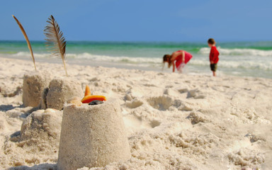 Fototapeta na wymiar Sand Castles and Kids Collecting Shells