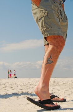 Man with tattoo on beach