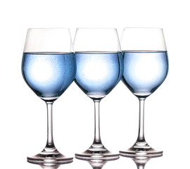 three wine glasses filled with blue fluid side by side