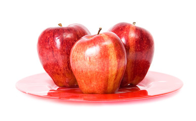 Three red apples on red plate