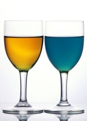 Two glasses with blue and yellow liquid