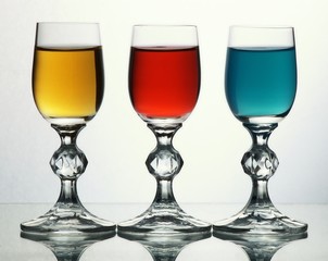 Three glasses with yellow, red and blue liquid