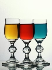 Three glasses with yellow, red and blue liquid