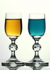 Two glasses with blue and yellow liquid