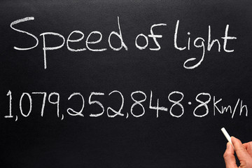 Writing the speed of light on a blackboard.