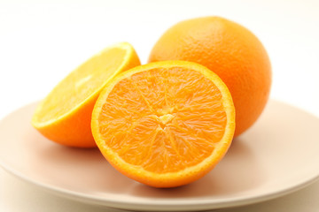 Oranges on plate isolated on white background
