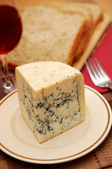 Fresh blue cheese with red wine and bread on the table