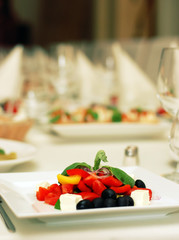 Greek salad with tomato, cheese and olives on table