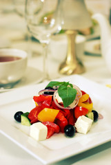 Greek salad with tomato, cheese and olives on plate