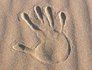Impronta di mano sulla sabbia