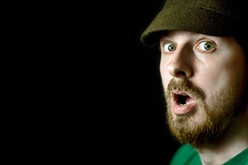 Closeup face of surprised shocked guy isolated on black
