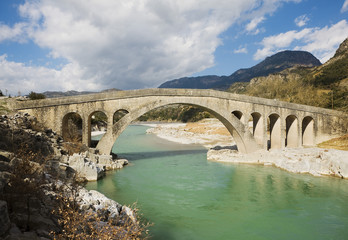 Fototapeta na wymiar Old stone bridge over a river