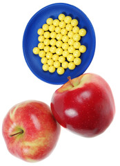 plateful of drops vitamin and apples above them