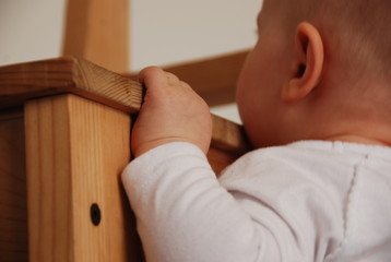 baby holding on to a chair