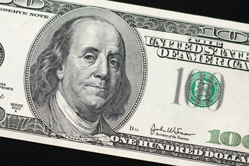 US $100 bill isolated on black background