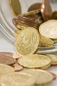 euro cents rolling out of pot.