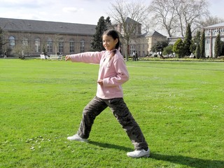 Chinesisches Mädchen übt Tai Chi im Park