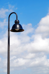 A single hooded street light with blue sky background