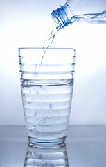 Glass of pouring water with reflection