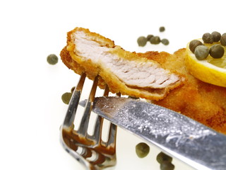 eine Scheibe Wiener Kalbsschnitzel auf Gabel und Messer