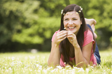 Fototapeta premium Woman relaxing in field on daisies