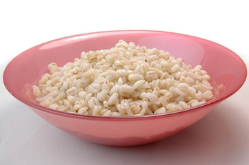barley groats porridge in red plate on white