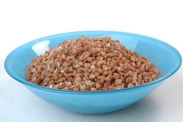 buckwheat groats porridge in blue plate on white