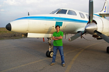 Young man beside airplane