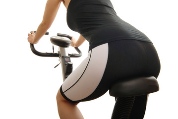 Isolated body of young woman riding on a spinning bicycle